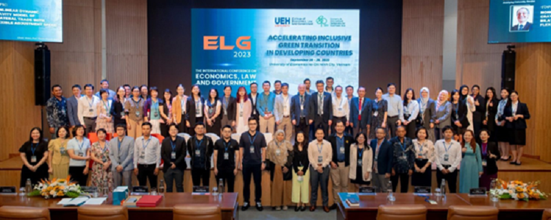 A group of people standing in front of a screenDescription automatically generated
